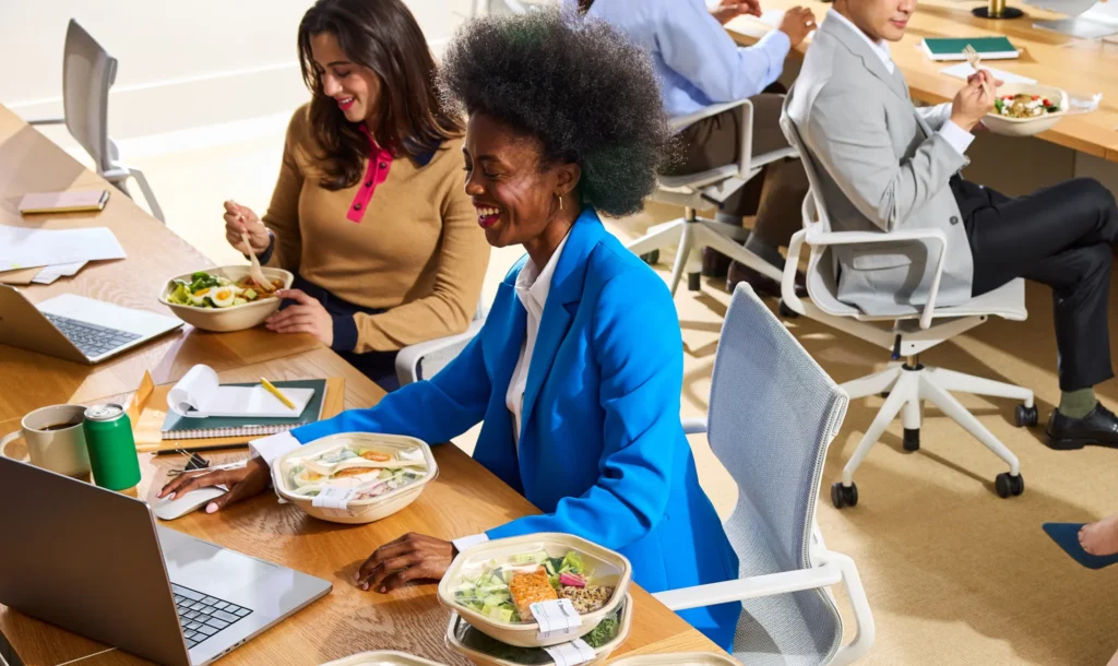 es collaborateurs partagent un déjeuner autour d’une table dans un espace de travail